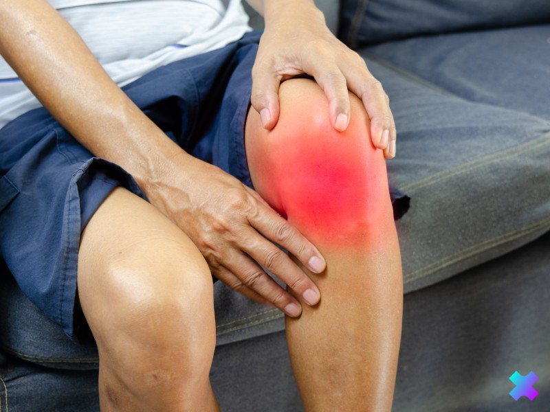 Mężczyzna trzymający się za staw promieniowo-nadgarstkowy - bóle stawów