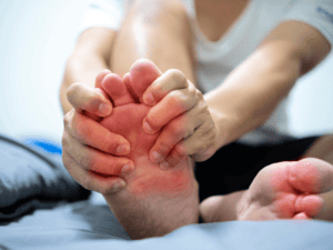 Osoba otrzymująca masaż stóp w celu łagodzenia objawów dna moczanowa.